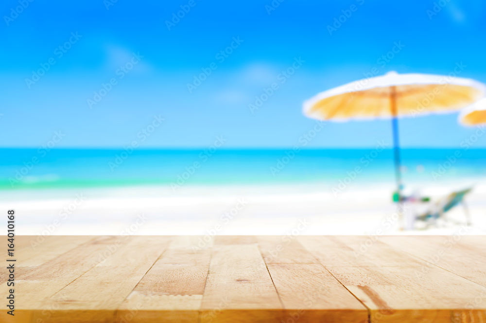 Wood table top on blurred blue sea and white sand beach background Wood table top on blurred blue sea and white sand beach background