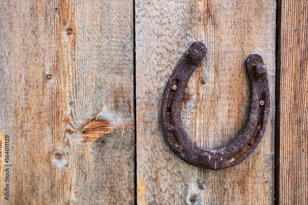 Old grunge horse shoe on wooden background Old grunge horse shoe on wooden background