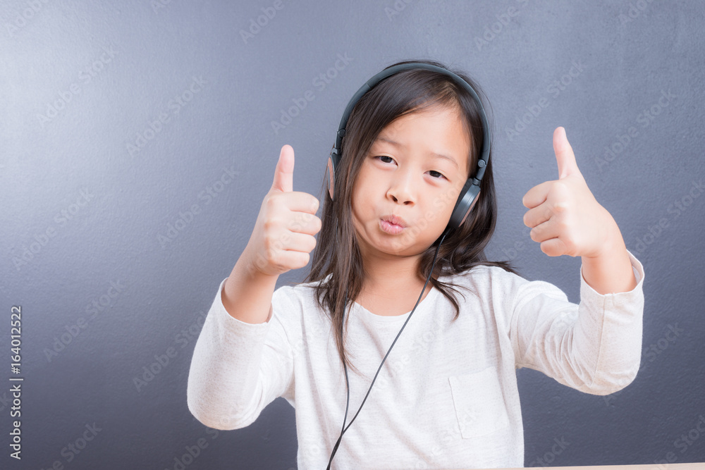 Portrait of asian little girl use headphone and smart phone Portrait of asian little girl use headphone and smart phone
