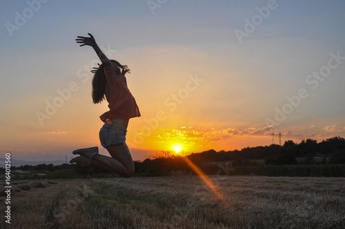 Beautiful Girl Enjoys the Sunset in the Field. Young Woman in Nature at Sunset