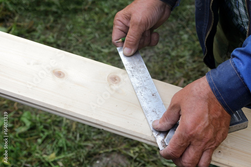 hands of a carpenter working with wood