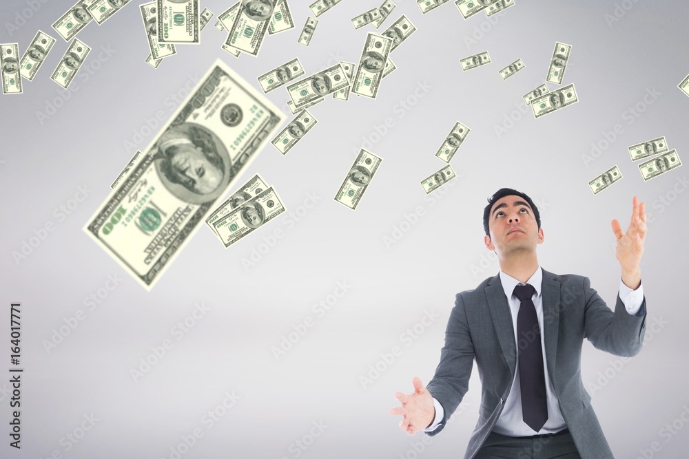 Business man looking at money rain against white background Business man looking at money rain against white background