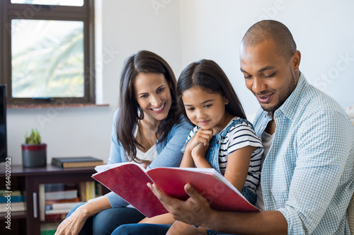 Parents looking daughter exercise book