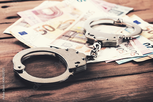 Fotobehang financial crime concept - money and handcuffs on the table