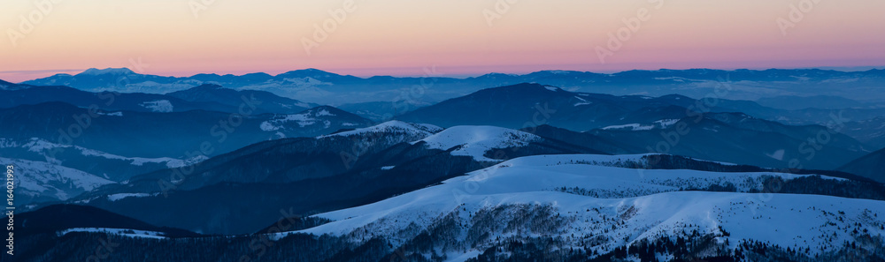 scenic sunrise, sunset in the winter mountains. mountain range panorama