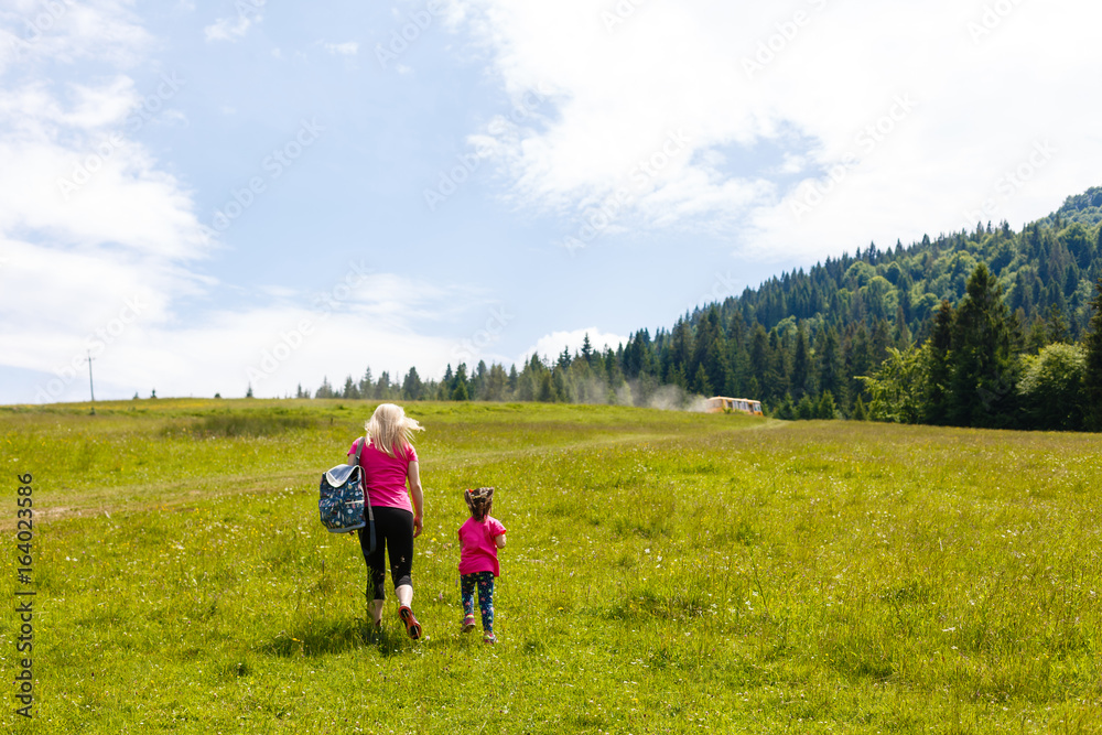 Fototapeta premium mother and little daugther hiking in mountains