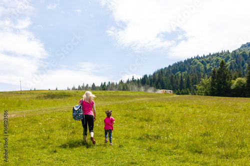 mother and little daugther hiking in mountains