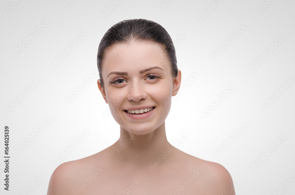 Young attractive girl smiling on a white background. Healthcare. Beautiful woman. Looks at the camera Young attractive girl smiling on a white background. Healthcare. Beautiful woman. Looks at the camera