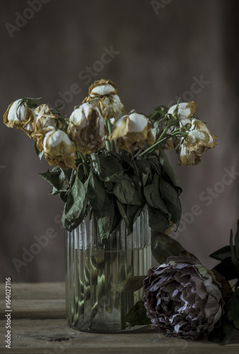 Dried roses in vase with dramatic lighting