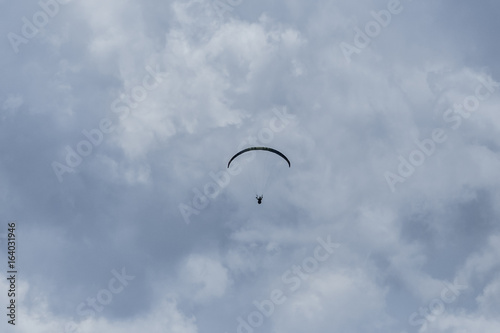 silhouette of paraglider in dark clouds