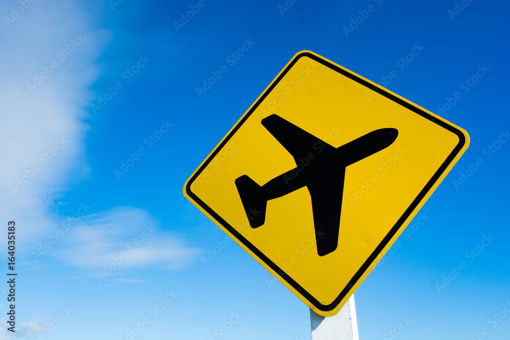 Yellow road sign with cloudscape and airplane spictogram Yellow road sign with cloudscape and airplane spictogram