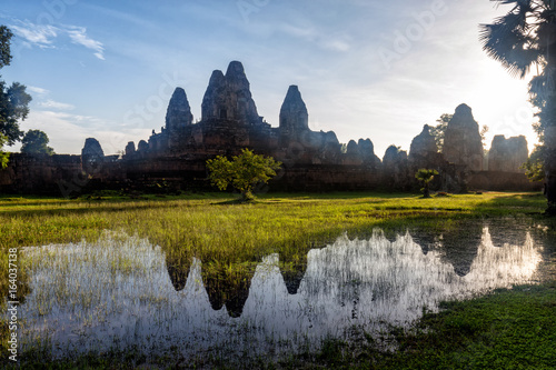 Early dawn light hits the Prae Roup Temple Complex and reflects it off of a pond in Siem Reap, Cambodia. photo