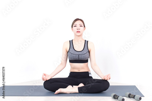 Young Fitness Asian woman doing yoga exercise in bedroom