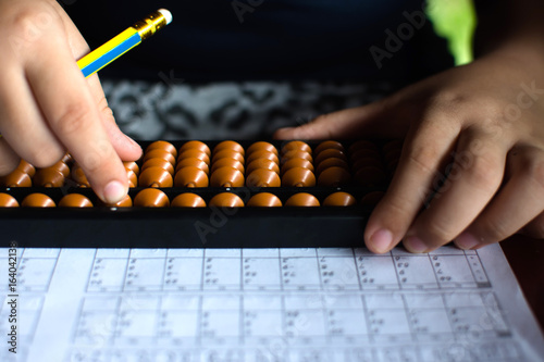 Cute little girl playing with abacus at home. Smart child learning to count.