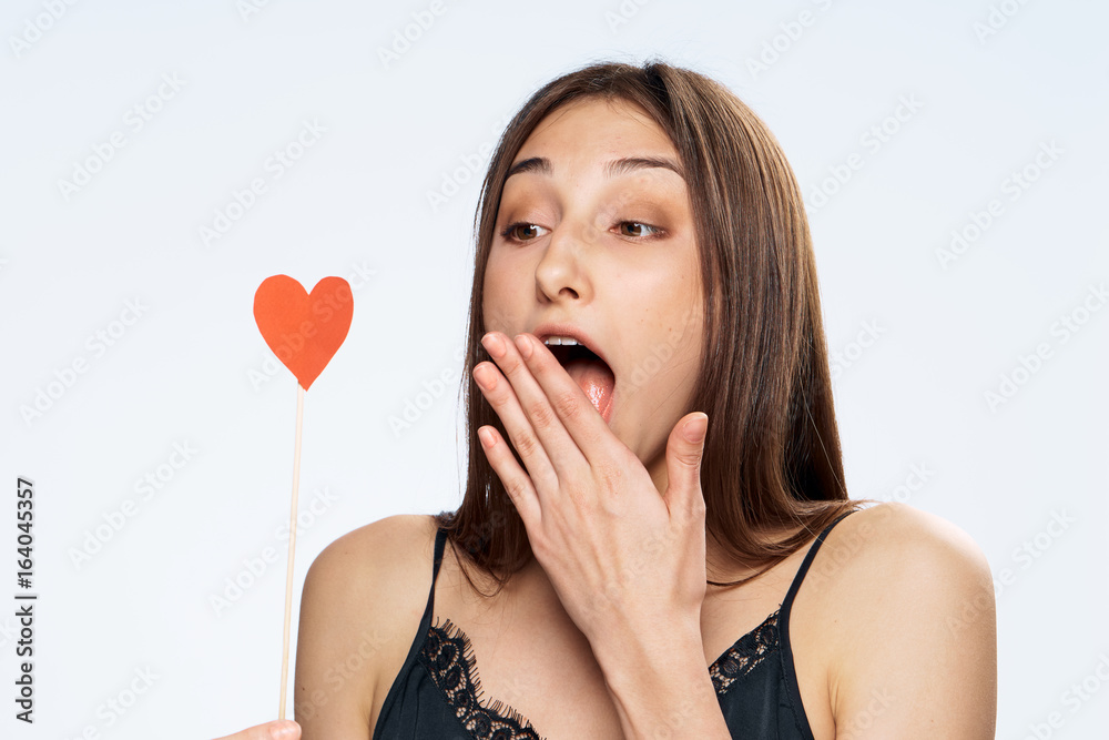 Beautiful young woman on white isolated background holds a paper accessory for parties Beautiful young woman on white isolated background holds a paper accessory for parties