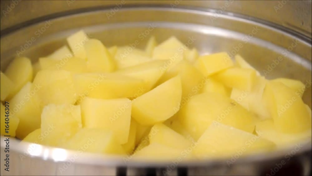 food preparation - A close up of steaming potatoes in a stainless steel steamer pot food preparation - A close up of steaming potatoes in a stainless steel steamer pot