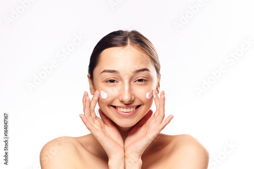 Beautiful young woman on white isolated background, cosmetic face cream