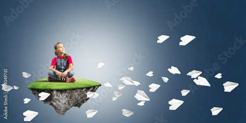 Concept of careless happy childhood with girl and paper planes flying around