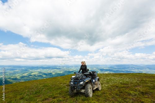 Happy woman riding a quad bike at the top of a mountain © Angelov