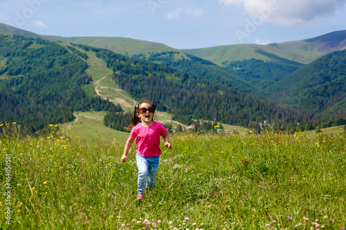 A little girl is running around the mountains