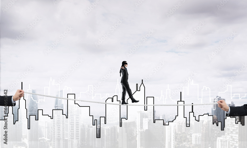 Business concept of risk support and assistance with man balancing on rope Business concept of risk support and assistance with man balancing on rope