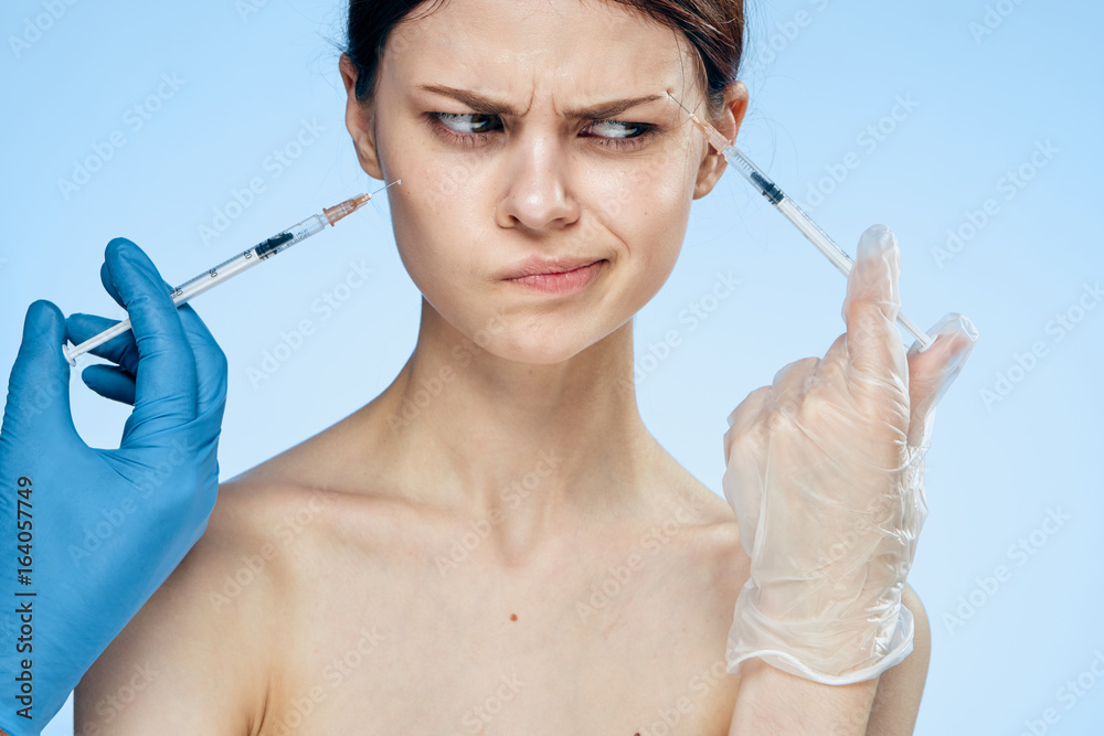 1157187 Beautiful young woman on a blue background holds a syringe, medicine, plastic 1157187 Beautiful young woman on a blue background holds a syringe, medicine, plastic