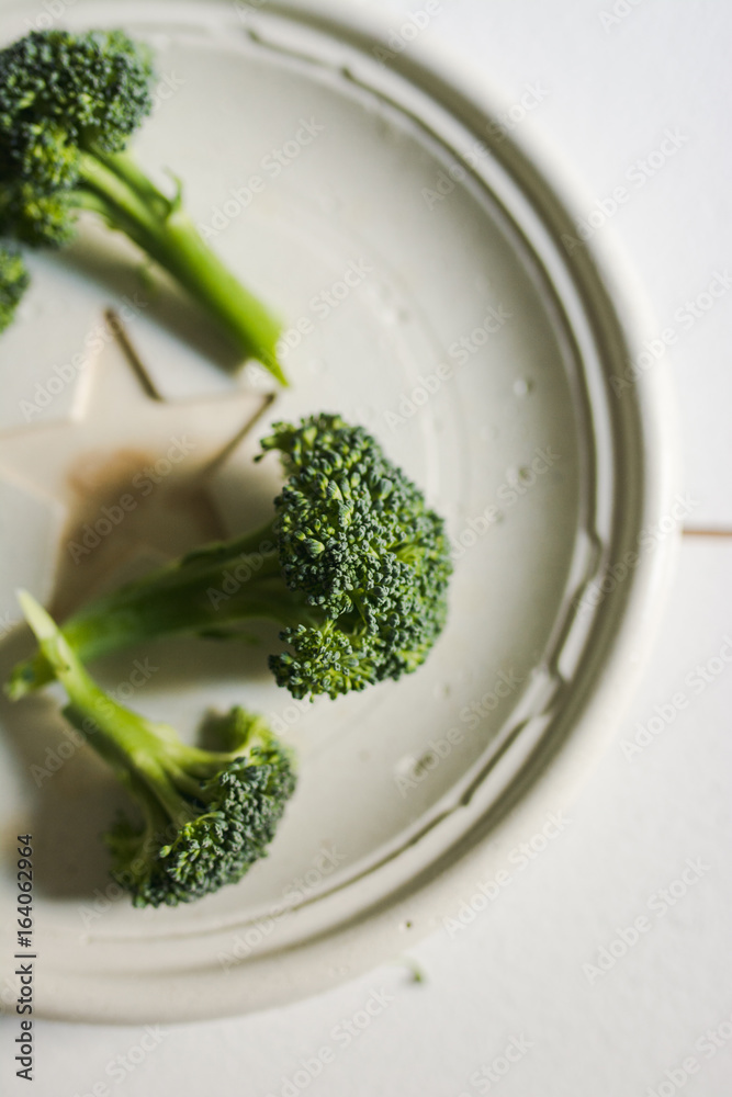 Piece of raw broccoli on concrete dish. From above Piece of raw broccoli on concrete dish. From above