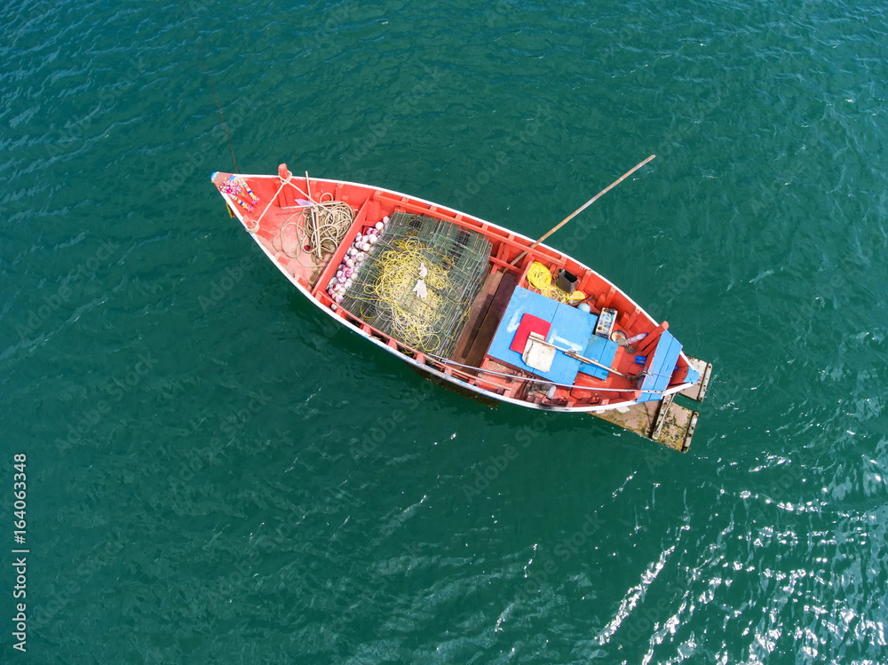 Fishing boat floating in the sea. The beautiful bright blue water in a  clear day.Aerial view.Top view. Stock Photo