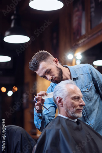 Handsome bearded barber modeling a haircut