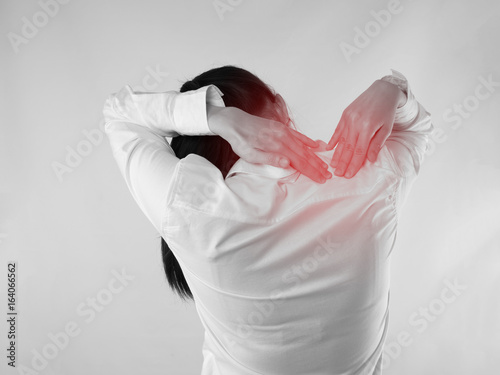 Young Asian woman touching back bone and having backache, concept of office worker health care lifestyle.