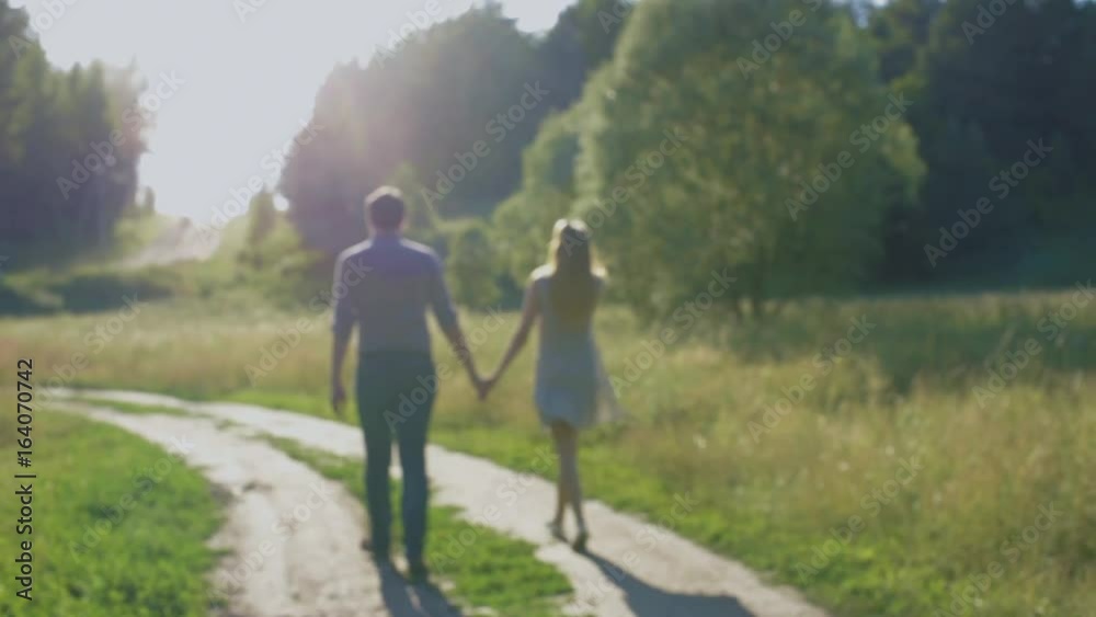 Boyfriend and girlfriend, loving couple walking and kissing at sunset in rural mestres on nature Boyfriend and girlfriend, loving couple walking and kissing at sunset in rural mestres on nature