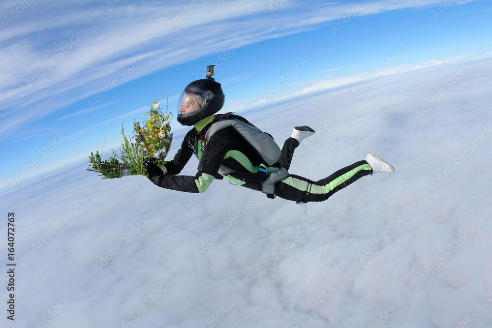 Skydiver girl with bouquet of daisy flawers.