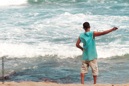 Man fishing line with hand on the seashore photo