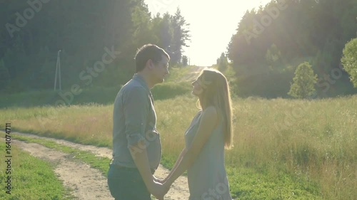 Boyfriend and girlfriend, loving couple walking and kissing at sunset in rural mestres on nature photo