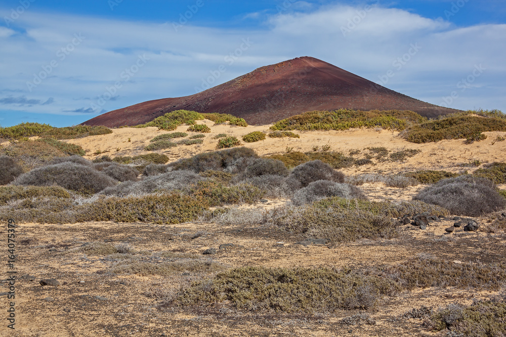 Picturesque red volcano illuminated by sunlight on Graciosa island, Lanzarote, Canary Islands, Spain Picturesque red volcano illuminated by sunlight on Graciosa island, Lanzarote, Canary Islands, Spain