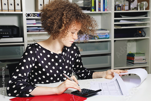 Foto jeune femme rousse stagiaire travaillant dans un bureau