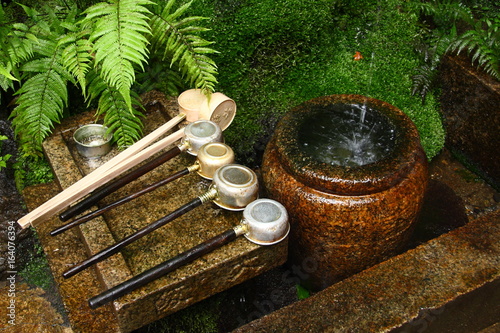 Water basin (tsukubai) and laddles for purification in a shinto shrine photo