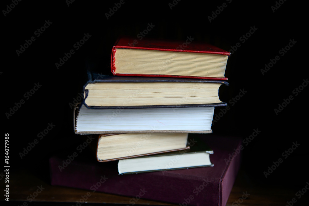 Fototapeta premium Paper books stacked shelf in the interior. Education and intelligence are well-read people. Old gadgets from short stories and novels. The passing of time read.