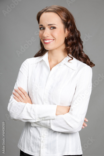 Smiling businesswoman, over gray