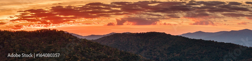 panoramic view of the rolling hills and forests in the Appalachian mountains during a spectacular orange morning sky and sunrise