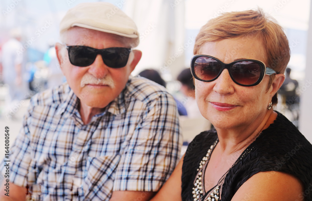 Portrait of senior couple sitting in summer cafe Portrait of senior couple sitting in summer cafe