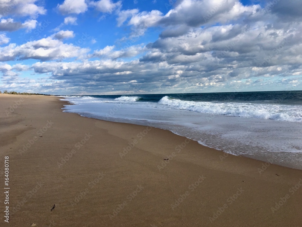 Beautiful empty sand beach with surfer waves and a blue sky with white clouds in Charlestown, Rhode Island (United States of America)