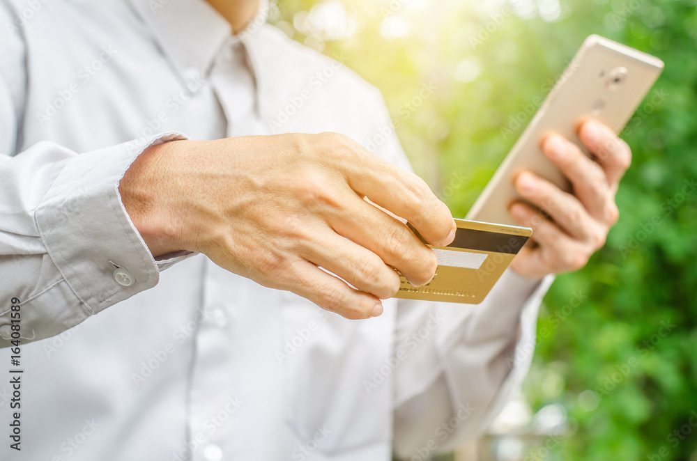 Online payment,Man's hands holding a credit card and using smart phone for online shopping