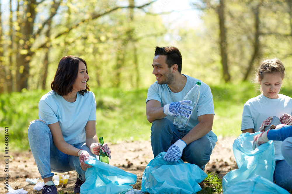 volunteers with garbage bags cleaning park area