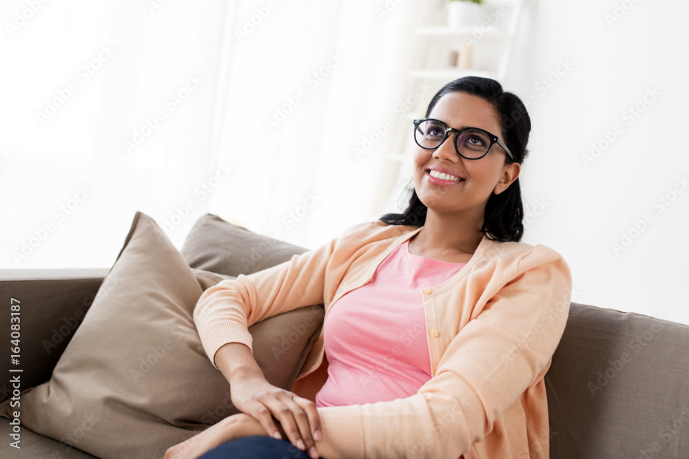 happy smiling young woman sitting on sofa at home happy smiling young woman sitting on sofa at home