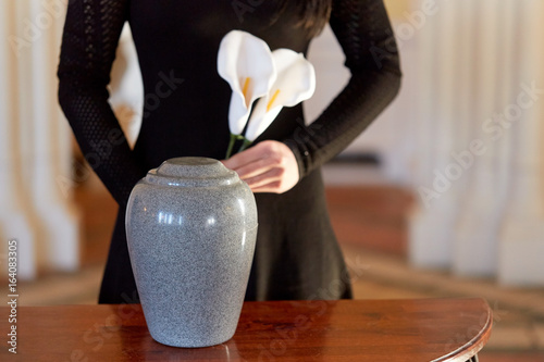 woman with cremation urn at funeral in church
