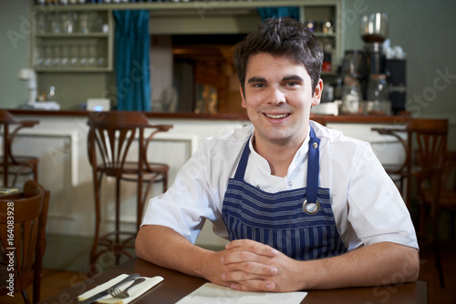 Εκτύπωση καμβά Portrait Of Chef Sitting At Table In Restaurant
