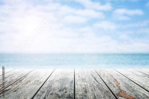 Empty wooden table with party on beach blurred background in summer time.