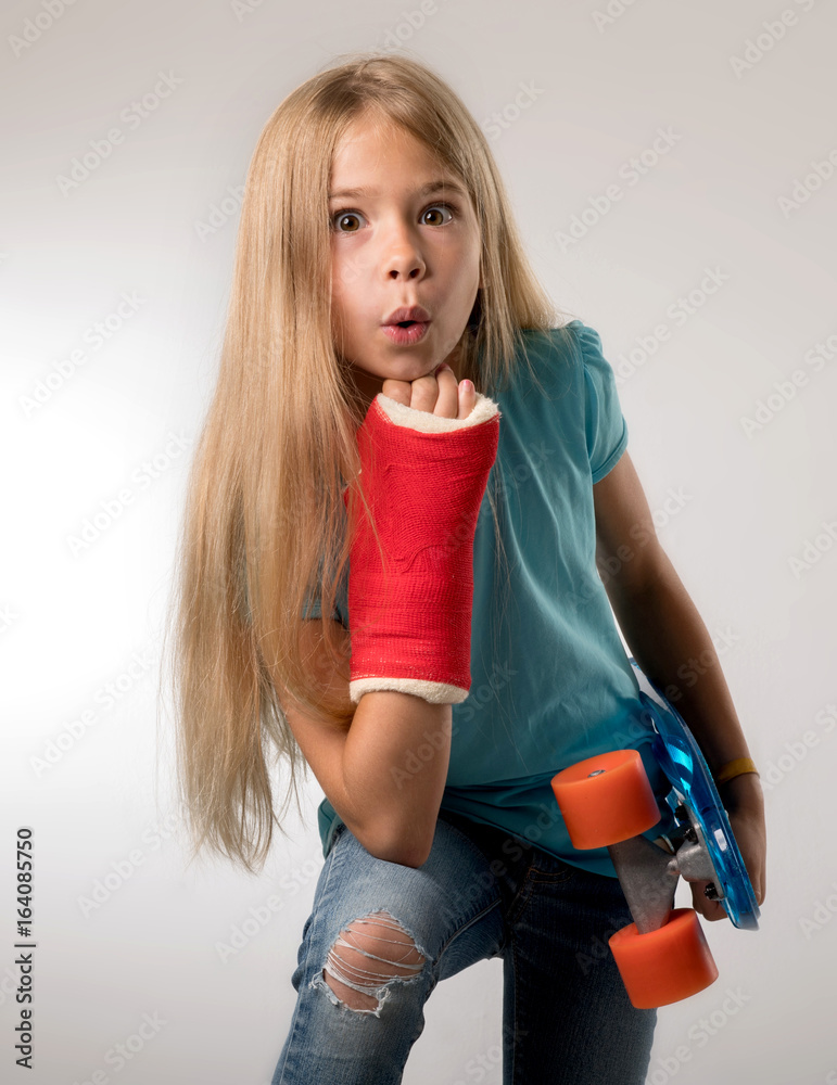 Mädchen mit gebrochenem Arm und Skateboard in der Hand erstaunter Blick Mädchen mit gebrochenem Arm und Skateboard in der Hand erstaunter Blick