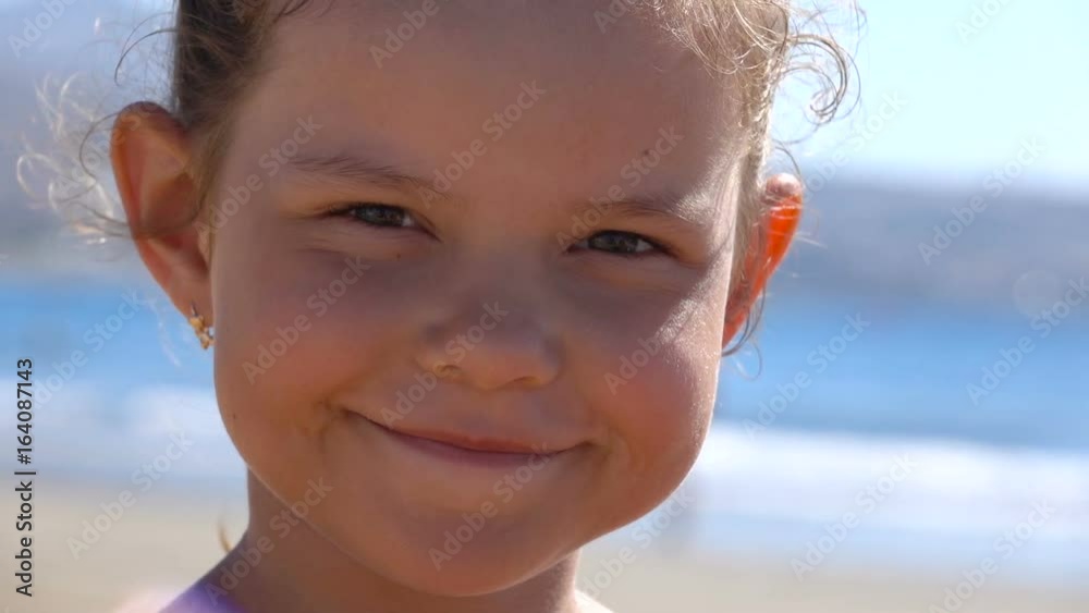 Child on the beach. She smiles. Slow motion. Child on the beach. She smiles. Slow motion.